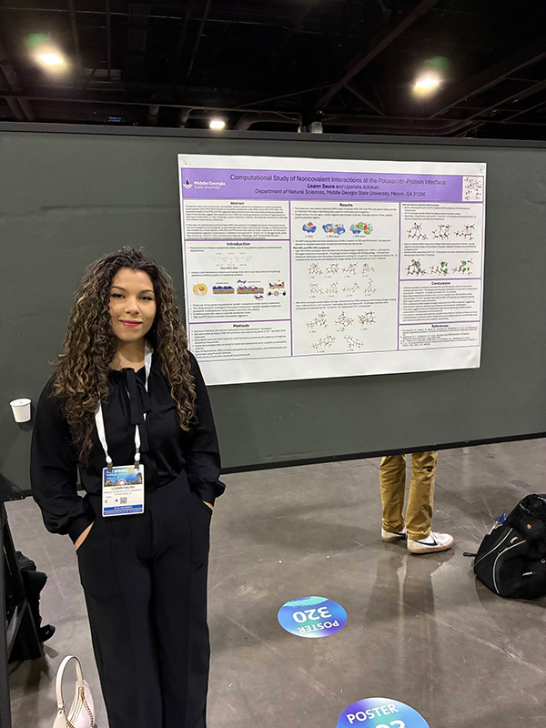 Leann Saura standing beside her research poster at the 2026 American Chemical Society meeting.